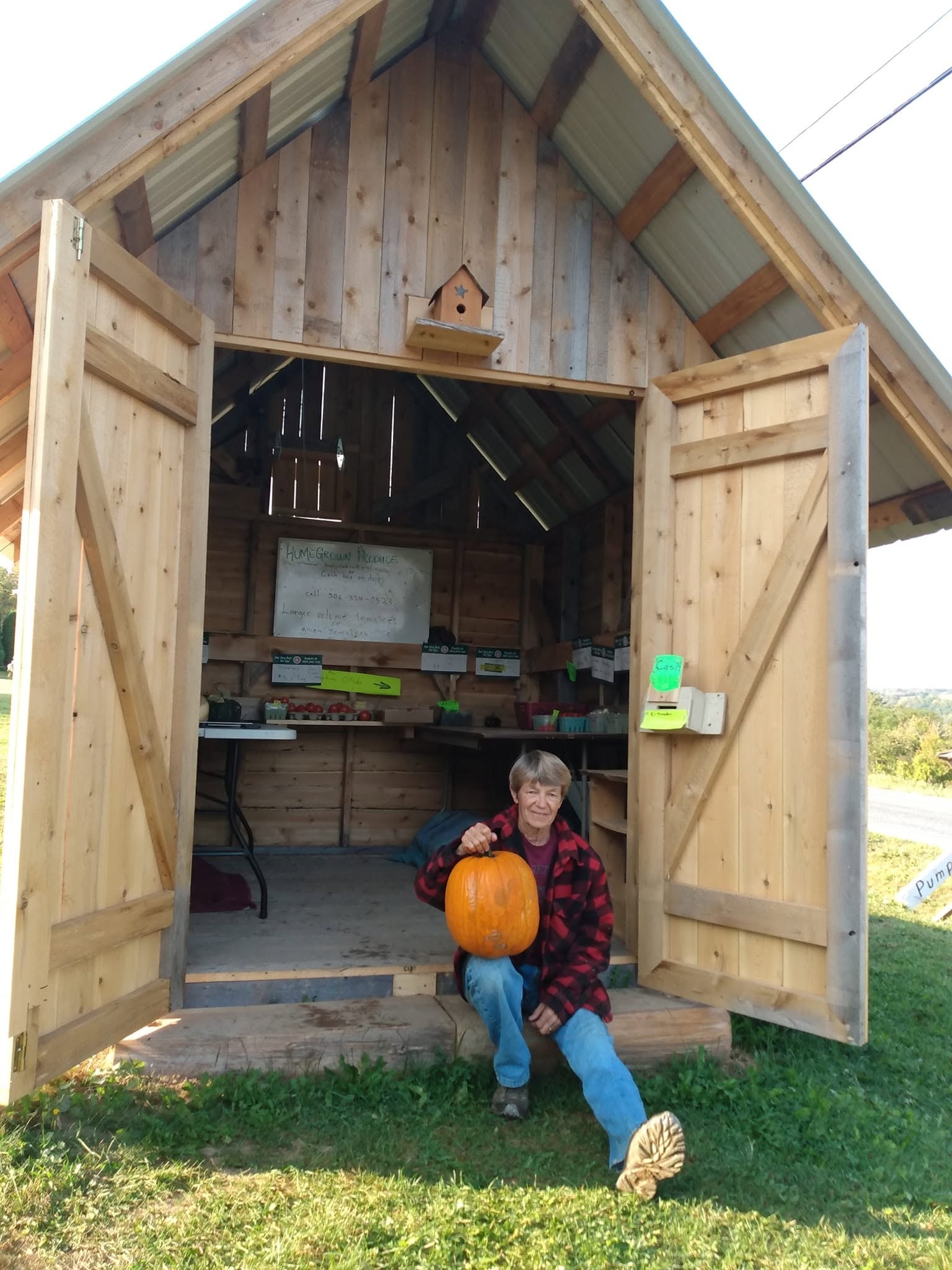 Barb Dickinson Clark sitting at her homegrown produce stand in Lower Brighton, NB