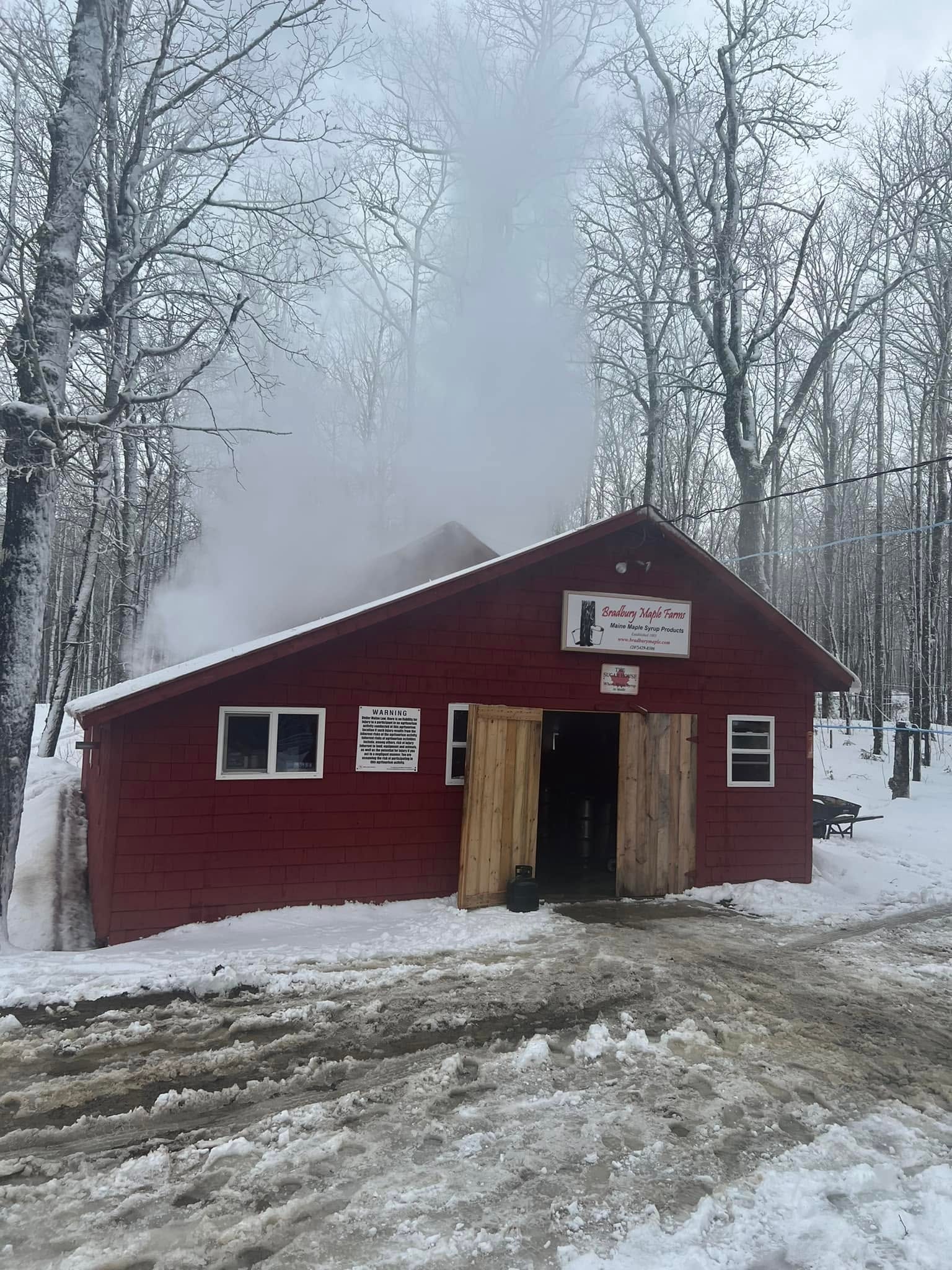 Bradbury Maple Farm red maple sugar shack in a snowy forest