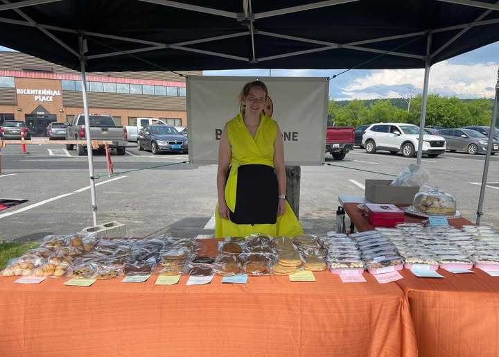 Nicoline at her Butterstone Bakery market stand with a full display of baked goods