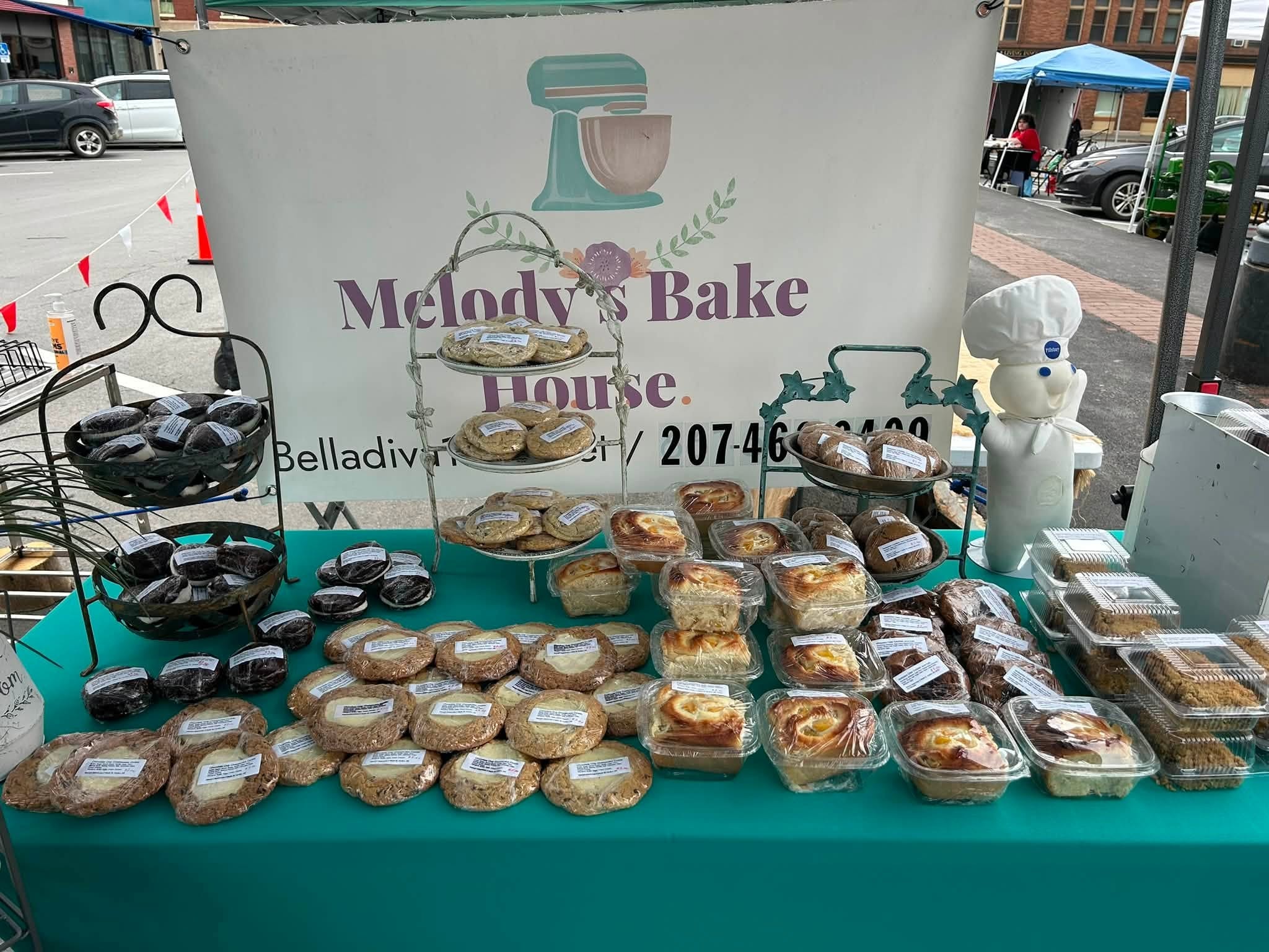 Melody's Bakehouse market stall displaying fresh packaged baked goods in Houlton, Maine